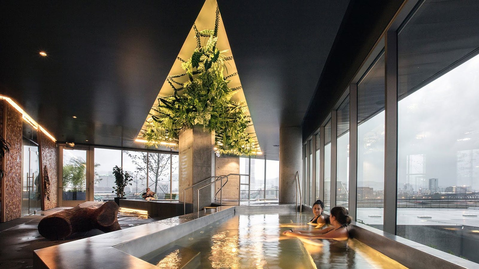 Spa and recovery floor with a stainless soaking pool, cold plunge and sauna beside floor-to-ceiling windows